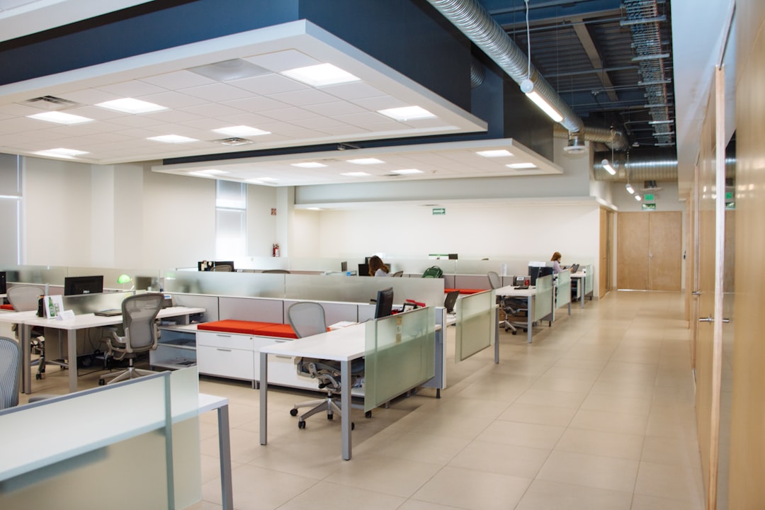 Oficina moderna de planta abierta con escritorios blancos