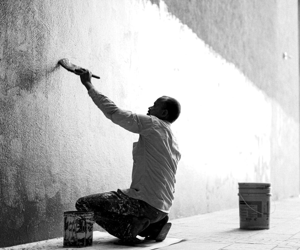 Pintor pintando una pared interior con rodillo